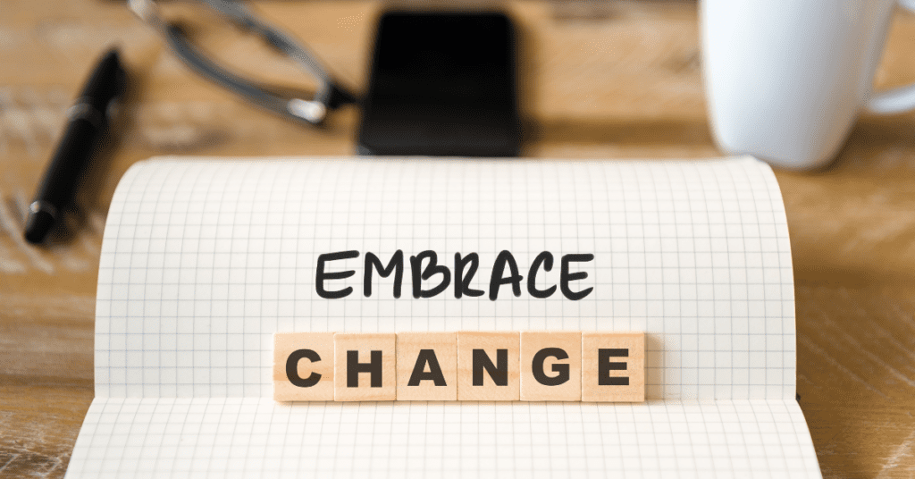 scrabble tiles on a desk that say "embrace change"
