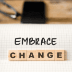 scrabble tiles on a desk that say "embrace change"